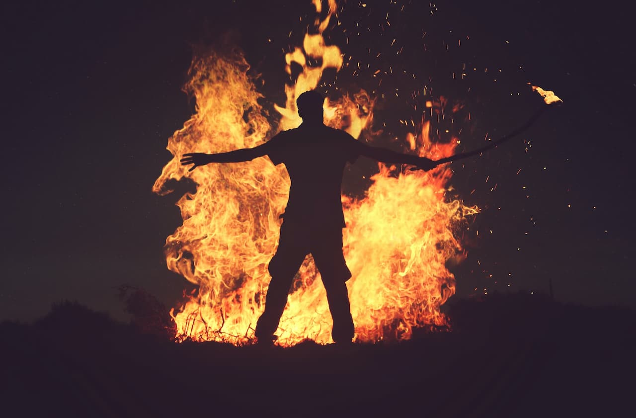 Silhouette of person near a burning bush
