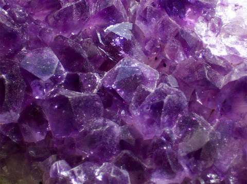Deep purple amethyst crystals forming a sparkling geode